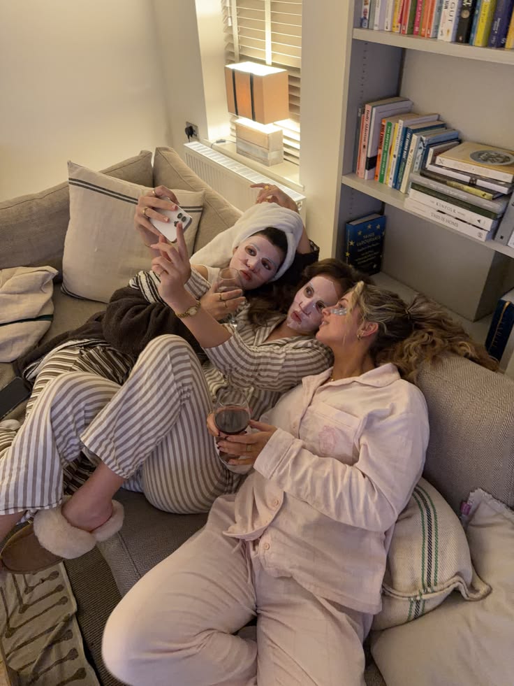 Friends in pajamas taking a selfie during a face mask night