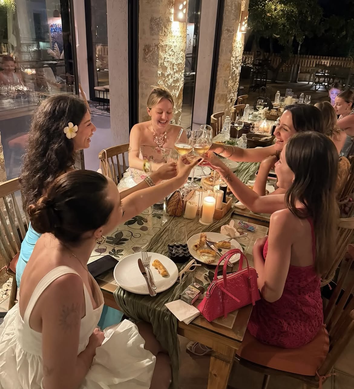 Friends clinking glasses at an outdoor dinner